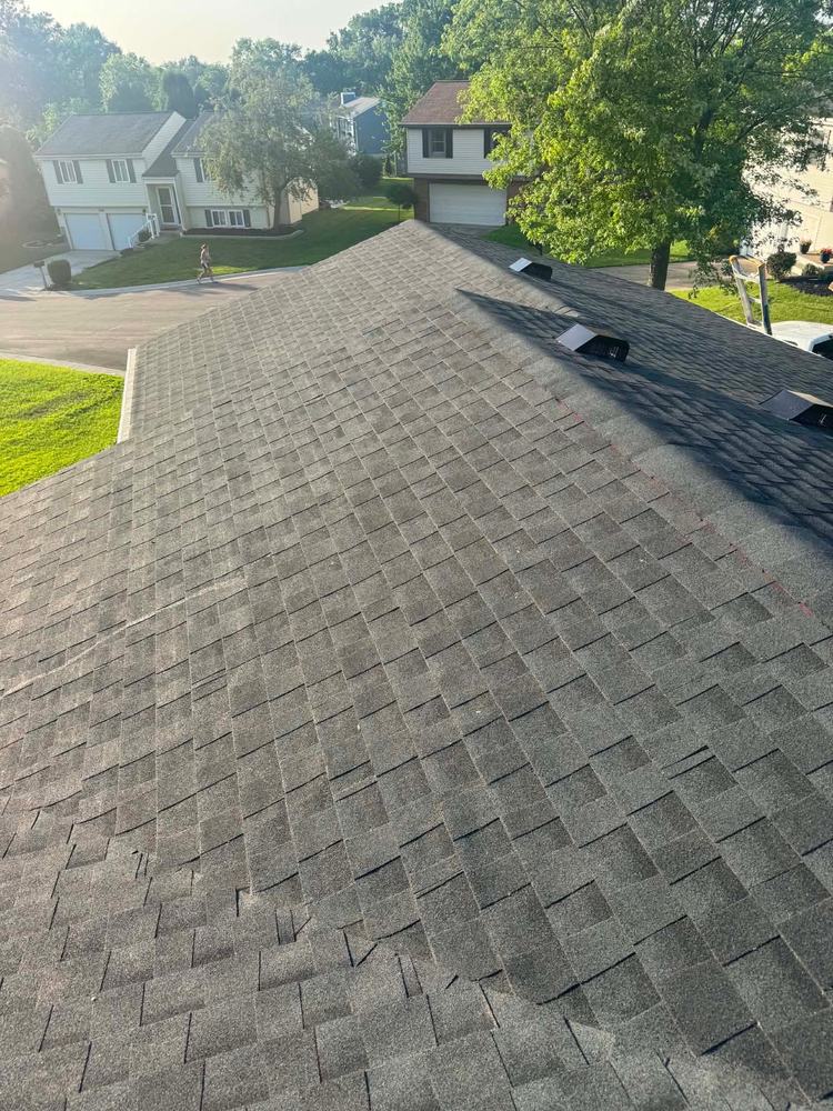 Finished architectural shingle roof with box vents on a suburban split-level