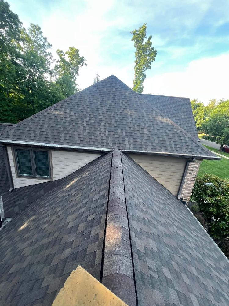 Completed roof across several planes on a stone and siding home