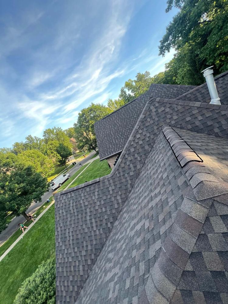 Hip and ridge cap detail on a finished weathered-wood shingle roof