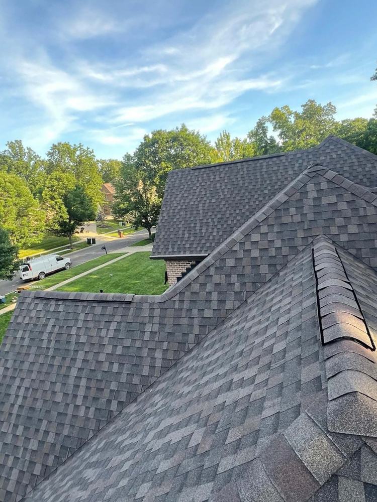 Hip and ridge cap detail on a finished weathered-wood shingle roof