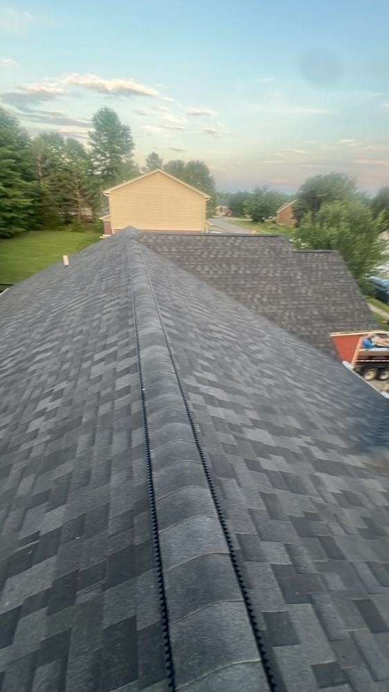 Ridge vent running along the peak of a finished dark shingle roof