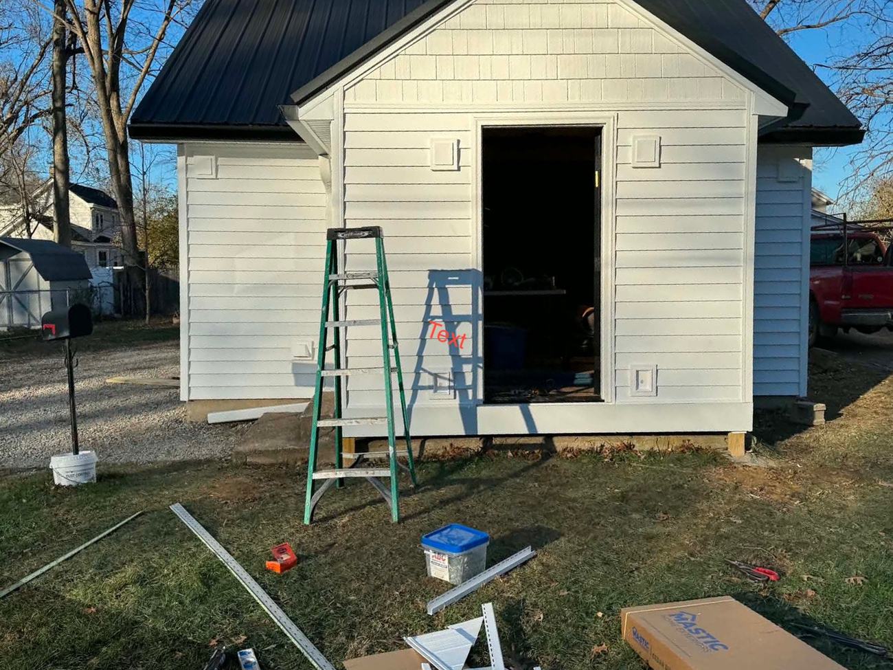 New white lap siding installed on a detached garage